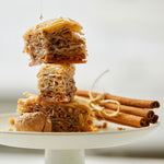 Baklava syrup drip, sitting on platter next to walnut and cinnamon